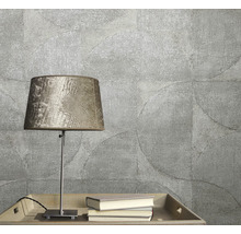 Prim-plan cu tapet texturat cu motiv circular, completat de o lampă de masă și cărți pe o tavă