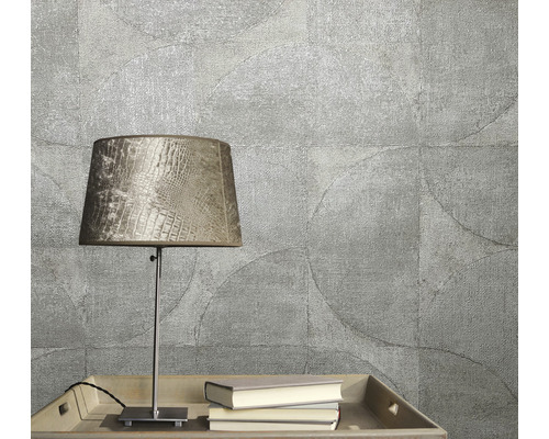 Prim-plan cu tapet texturat cu motiv circular, completat de o lampă de masă și cărți pe o tavă