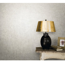 Tapetă decorativă cu suprafață texturată lângă o lampă de masă.