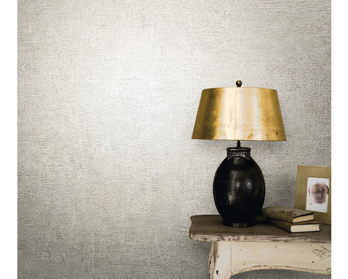 Tapetă decorativă cu suprafață texturată lângă o lampă de masă.