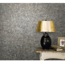 Prim-plan cu tapet cu model pe perete, instalat lângă o masă cu o lampă și decorațiuni