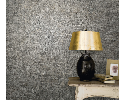 Prim-plan cu tapet cu model pe perete, instalat lângă o masă cu o lampă și decorațiuni