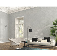 Cameră de zi cu tapet gri cu model, canapea, fotoliu și plantă de interior