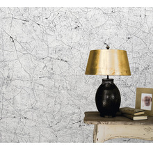 Tapet cu model crăpat lângă lampă de masă și ramă foto