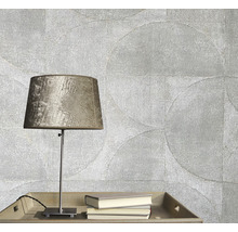 Tapetă decorativă cu model circular, veioză și cărți pe o masă