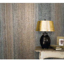 Prim-plan cu o cameră cu tapet texturat, o lampă și o măsuță laterală.