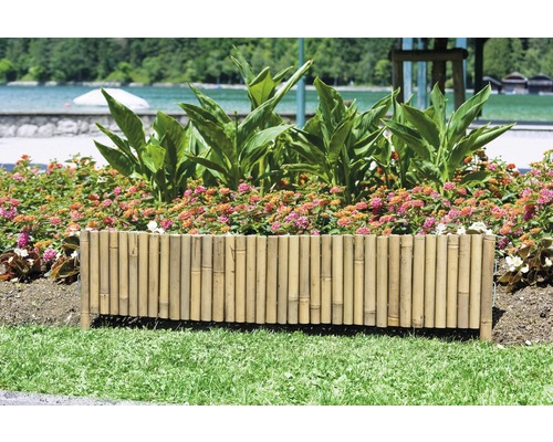 Jardinieră din bambus cu plante cu flori într-o grădină