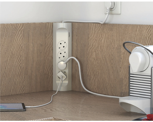 Priză de colț cu dispozitive conectate pe un blat de lucru