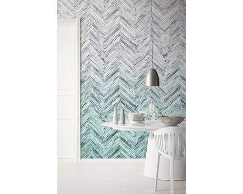 O sală de mese cu tapet cu model herringbone, o masă rotundă și scaune.