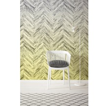 Interior decorativ cu un scaun alb și o lampă de podea în fața unui perete cu model herringbone