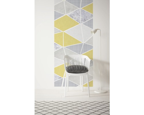 Tapetă decorativă cu model geometric triunghiular, scaun alb cu pernă și lampă de podea pe un covor cu model.