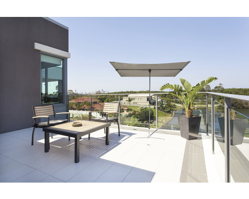 Terasa cu zonă de relaxare, umbrelă de soare și jardiniere