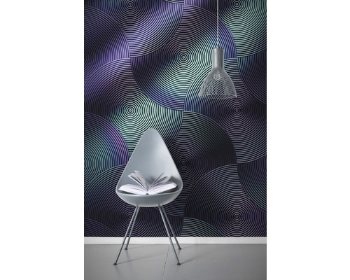 Imagine dintr-o cameră cu tapet de perete cu cercuri concentrice, un scaun cu o carte și o lampă suspendată