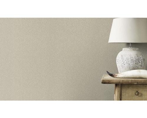 Prim-plan cu un tapet cu model subtil lângă o noptieră cu lampă