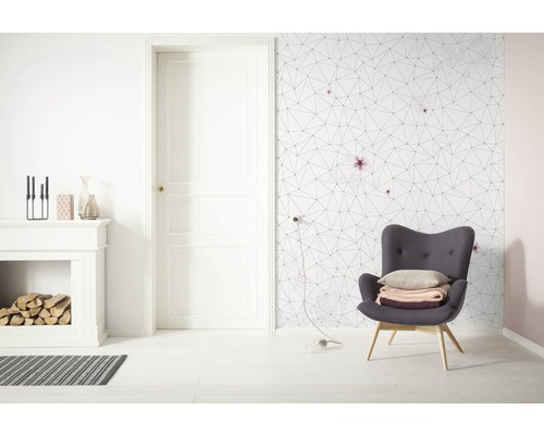 Cameră de zi luminoasă cu șemineu, fotoliu și tapet geometric