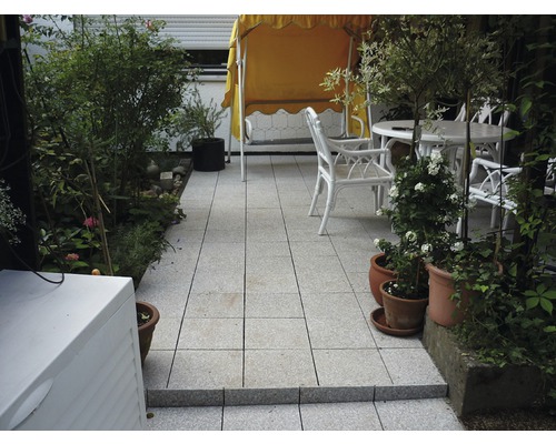 Terasa cu mobilier de grădină și plante pe plăci de piatră