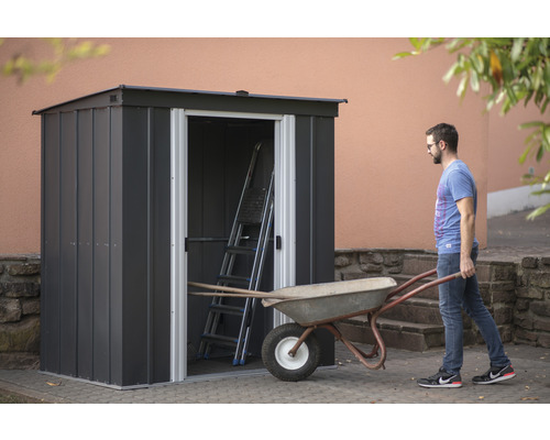 Dulap de grădină cu ușa deschisă, scară și roabă în grădină