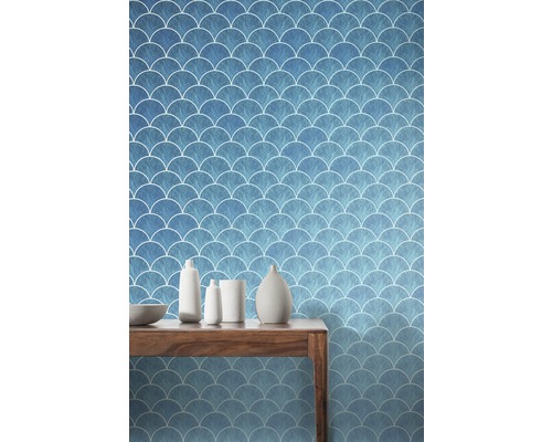 Scenă cu un tapet albastru cu model de solzi de pește și o masă din lemn cu decorațiuni