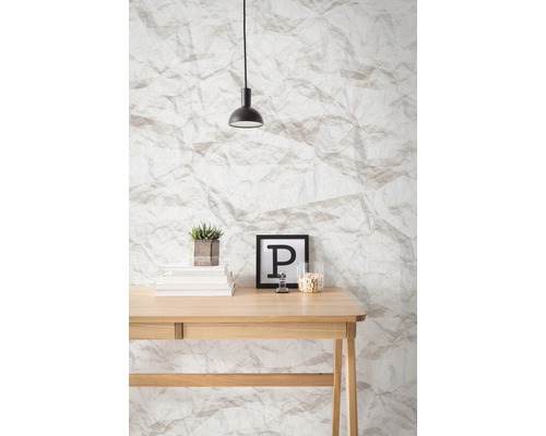 Birou cu decoratiuni in fata tapetului cu aspect de hartie si lampa suspendata