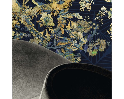 Imagine detaliată a unei camere cu tapet cu model floral și vedere parțială a unui fotoliu.