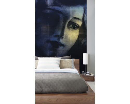 Dormitor cu fototapet cu chip de femeie în spatele unui pat din lemn.