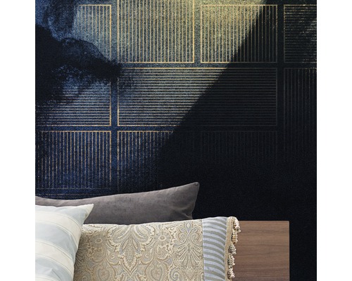 Prim-plan al unui perete cu tapet vlies de culoare albastru închis cu model și accente aurii deasupra unui pat