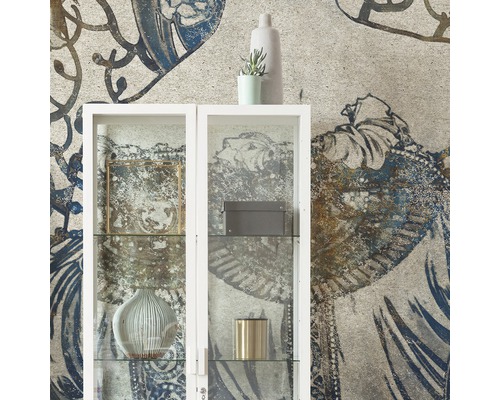 Living decorativ cu un dulap de sticlă alb în fața unui tapet cu model.