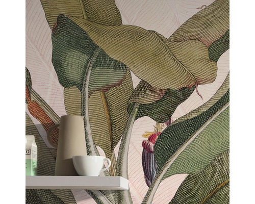 Prim-plan al unei camere cu tapet cu model de frunze de bananier, un raft, un ulcior și o ceașcă