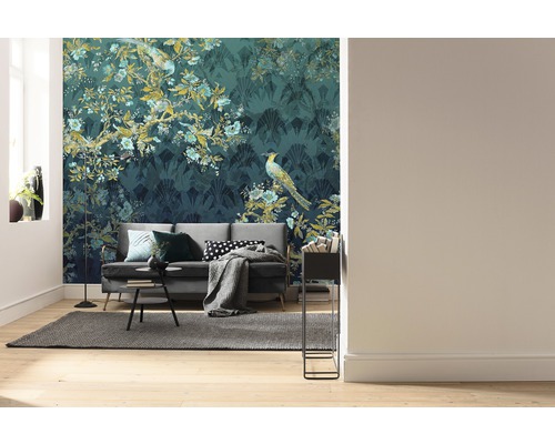 Living cu canapea în fața unui tapet cu modele cu motive de plante și păsări