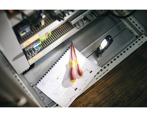 Unelte de electrician și schemă electrică într-o cutie de distribuție