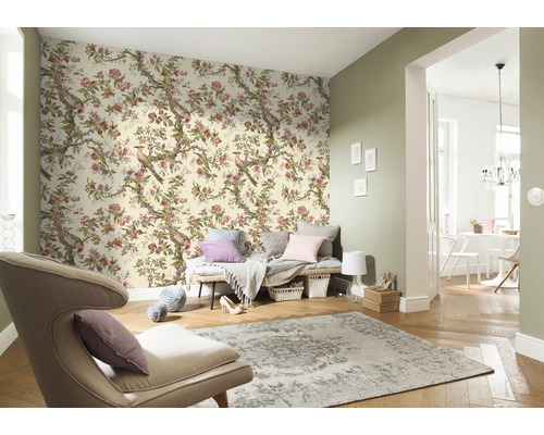 Living cu tapetă florală cu motive de păsări, fotoliu și covor pentru un ambient luminos și organizat.