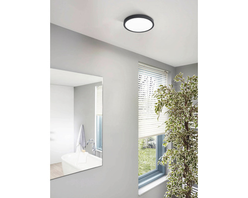 Scenă a unei băi cu o plafonieră rotundă.