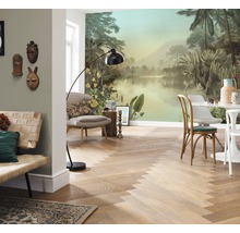 Cameră de zi cu fototapet tropical, podea din lemn cu model herringbone, mobilier de ședere și lampă de podea.
