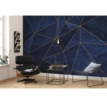 Cameră de zi cu tapet cu model geometric albastru-auriu, fotoliu și măsuțe laterale.