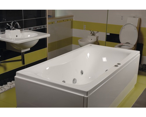 Amenajare baie cu cadă, chiuvetă, bideu și toaletă în fața plăcilor de faianță în dungi.