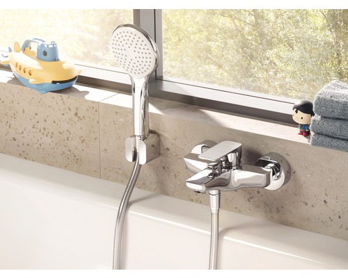 Baterie de duș aparentă cu duș de mână și furtun de duș montată pe o cadă.