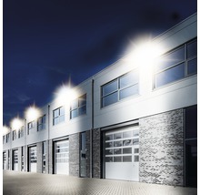 Clădire comercială cu mai multe ferestre, uși de garaj și iluminat exterior