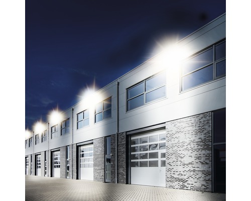 Clădire comercială cu mai multe ferestre, uși de garaj și iluminat exterior