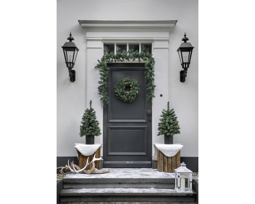 Zona de intrare cu decorațiuni de Crăciun: coroană de ușă, ghirlandă, brazi, lanternă și coarne