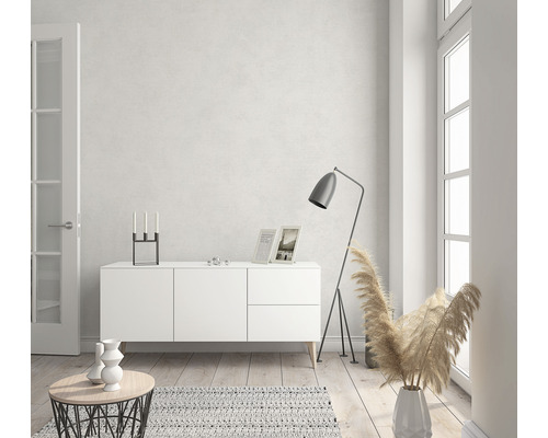 Living luminos cu bufet alb, lampă de podea și decorațiuni.