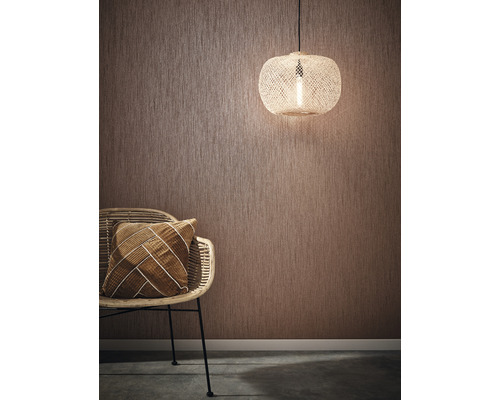 Scenă de cameră cu tapet texturat, scaun de ratan, pernă și lampă suspendată