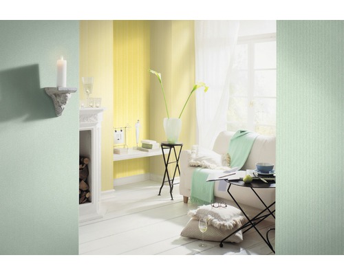 Cameră de zi luminoasă cu tapet galben, canapea și decorațiuni