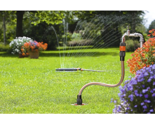 Grădină cu aspersor de gazon și robinet de apă pentru irigare.