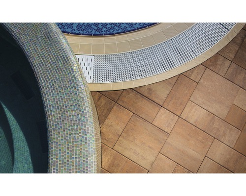 Prim-plan al unei piscine cu plăci de mozaic, plăci de pavaj și rigolă de scurgere