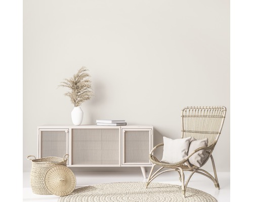 Scenă de living cu comodă, fotoliu din ratan, covor și decorațiuni pentru o ambianță luminoasă și prietenoasă