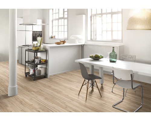 Bucătărie luminoasă cu podea din lemn, masă și cărucior de bucătărie.