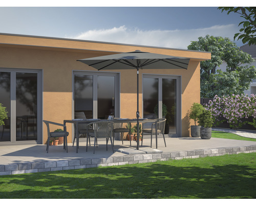 Set de mobilier de grădină cu masă, scaune și umbrelă de soare pe o terasă în fața unei case