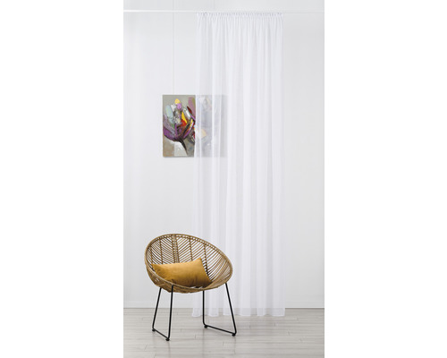 Cameră decorativă cu draperie albă transparentă, fotoliu din ratan și pictură murală
