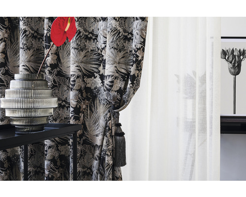 Living decorativ cu perdele cu model, vază de sticlă și măsuță laterală elegantă