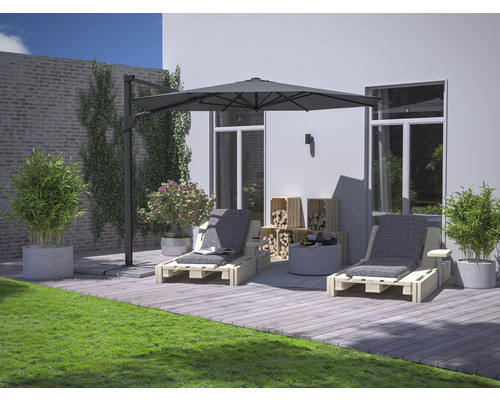 Scenă de grădină cu două șezlonguri din lemn, umbrelă de soare, lăzi din lemn, plante și gazon